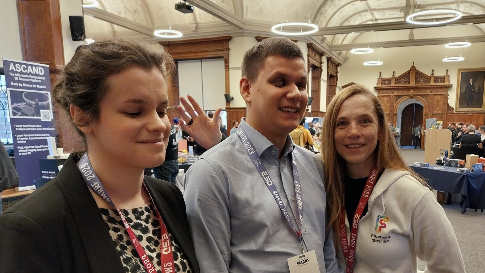 Dawid, Julita i Magda z plakietkami wystawców na szyi stoją na tle sali, w której odbyło się wydarzenie.