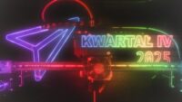 Obrazek w stylu cyberpunk. Za drukującą Rozalią (drukarką 3D Prusa Core One), niby przy jej tylnej ścianie na lewo od dyszy lśni cienki neonowy różnokolorowy zaślepiający kadr kontur samolocika. Po prawej od dyszy jeszcze bogatszy w kolory, nieco zasłonięty stołem drukarki, ale wciąż czytelny kontur liter "KWARTAŁ 4 2025". Taki styl kojarzy się z atmosferą klubową, a jednocześnie z poważnym laboratorium badawczym.