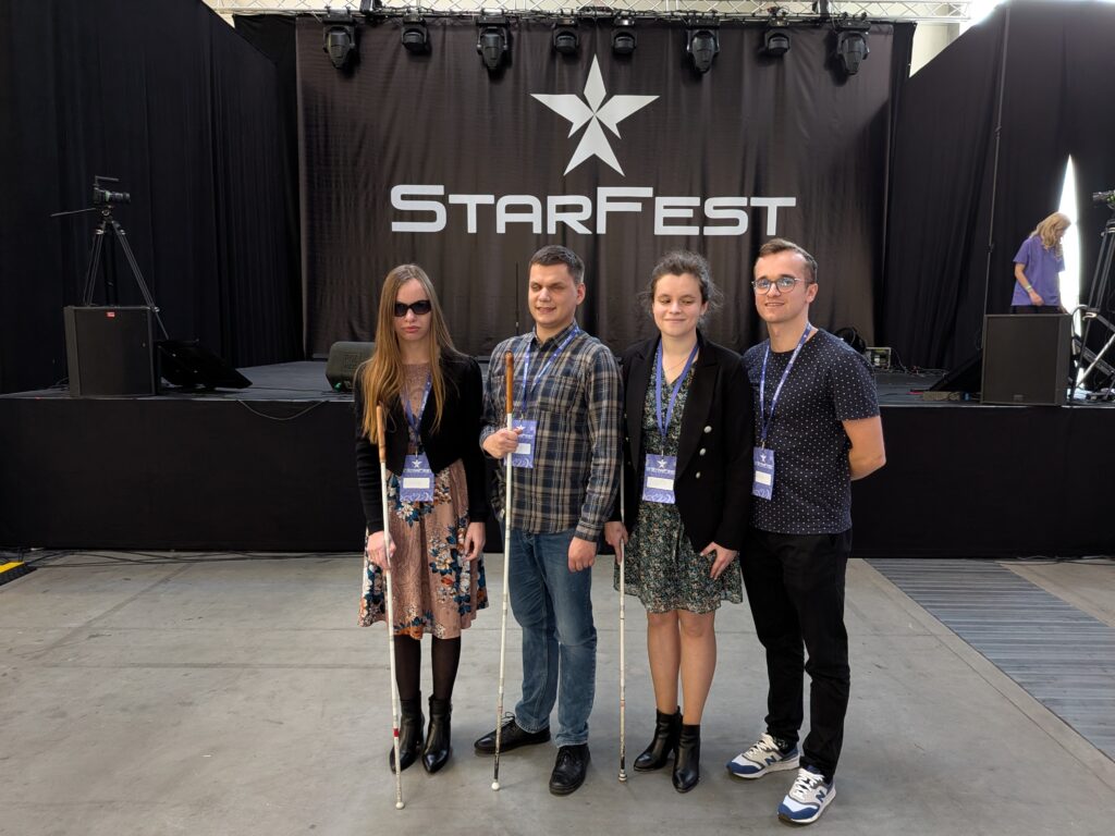 zarząd z laskami i Rafał stoją przed sceną z logiem starfest
