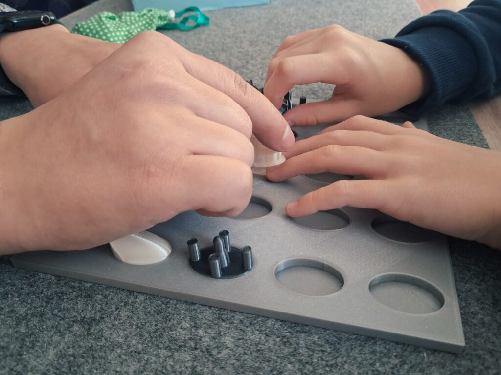 Widok z bliska na grające w Zbijanki i wyścigi dwie pary dłoni.