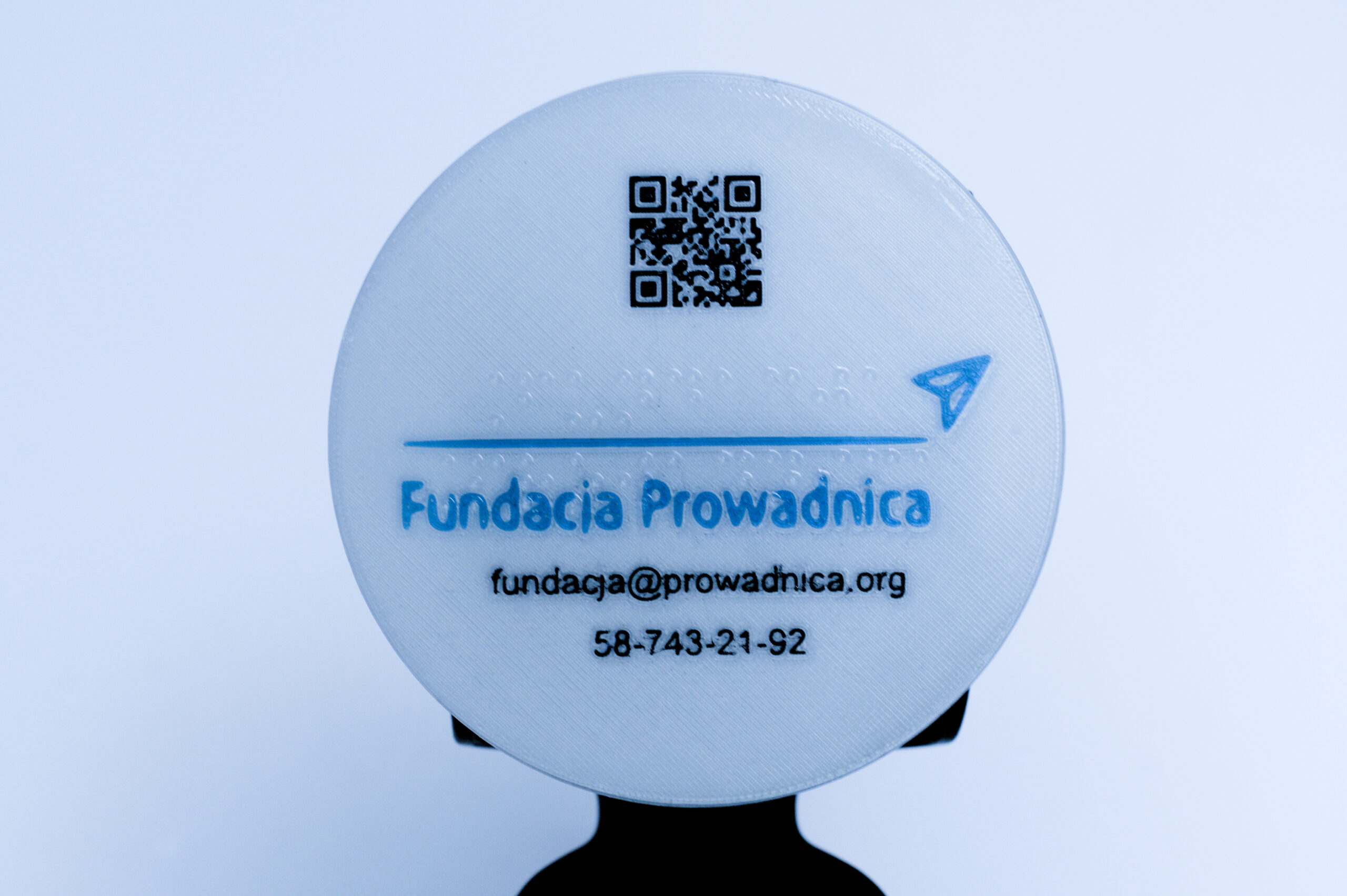 Koło z brajlowskim napisem Fundacja Prowadnica, w poddruku kod QR do strony Fundacji, logo i dane kontaktowe