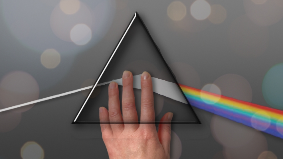 Grafika to nawiązanie do albumu Pink Floyd "The Dark Side of the Moon." Czarne tło, po środku trójkąt. Od lewej płynie w jego stronę biały obłok światła, który załamuje się w środku trójkąta, by z jego prawej strony stać się tęczą. Trójkąta dotyka dłoń. Na całej grafice kolorowe, półprzejrzyste bąbelki.
