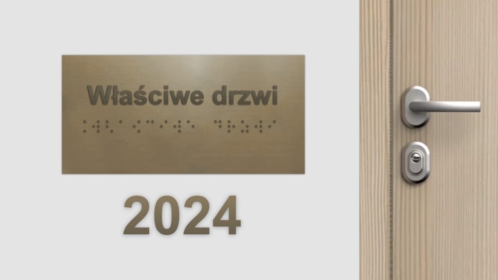 Na ścianie wisi tabliczka z napisem w czarnodruku i brajlu „właściwe drzwi.” Po prawej od tabliczki drewniane drzwi z metalową klamką. Pod tabliczką tekst „2024.”