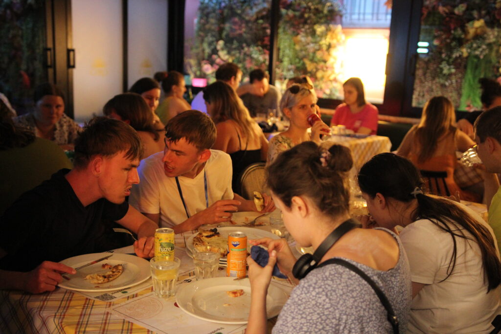 Uczestnicy polskiej grupy w ładnie urządzonej pizzerii; na pierwszym planie Julita oraz bliźniacy Mikołaj i Maciek.